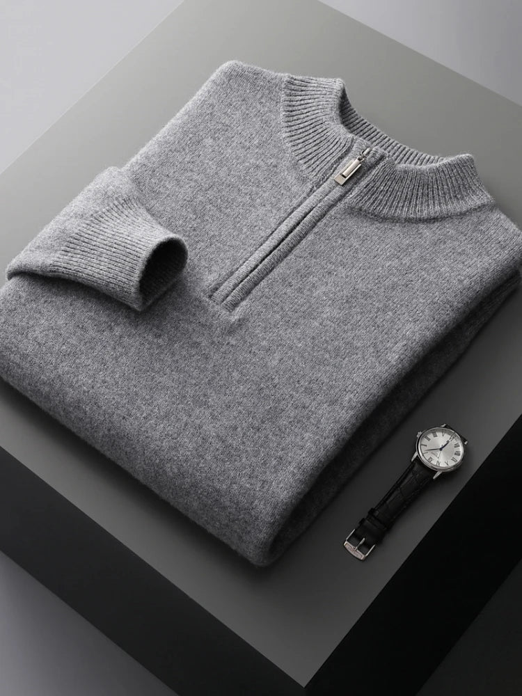 Pull gris en laine avec fermeture éclair, posé sur une table grise, accompagné d'une montre-bracelet élégante en acier inoxydable.