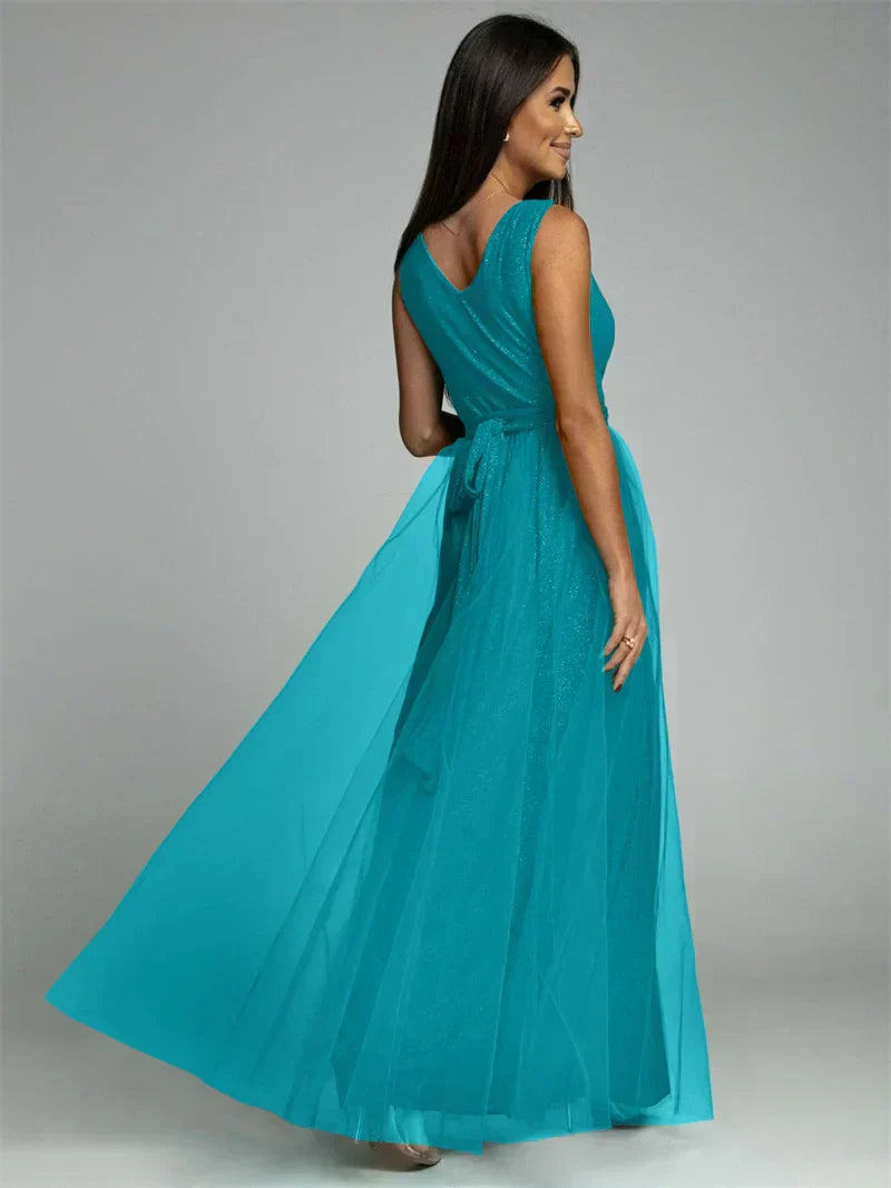 Femme portant une robe longue turquoise élégante, dos nu, en tulle fluide, idéale pour soirées et événements formels. Mode féminine chic.