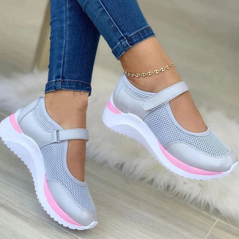 Chaussures de sport femme grises et roses, design moderne, semelle épaisse antidérapante, portées avec un jean bleu, style décontracté et tendance.