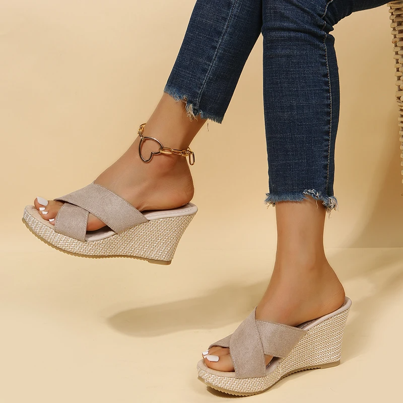 Sandales compensées beiges en toile, portées avec un jean ajusté. Chaussures d'été élégantes pour femmes, idéales pour un look décontracté et tendance.