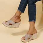 Sandales compensées beiges en toile, portées avec un jean ajusté. Chaussures d'été élégantes pour femmes, idéales pour un look décontracté et tendance.