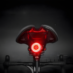 Selle de vélo avec feu arrière LED rouge allumé, sécurité cycliste, accessoire nocturne, visibilité accrue, équipement vélo moderne.