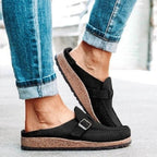 Chaussures mules noires avec semelle en liège, portées avec un jean retroussé. Confortables et tendance, idéales pour un style décontracté.
