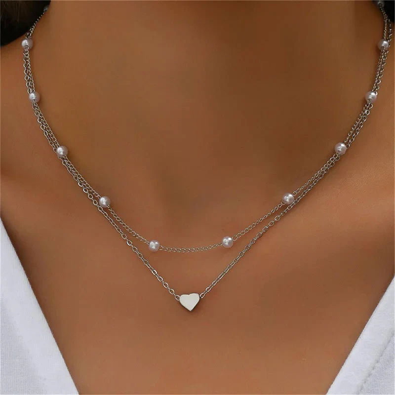 Collier double rang en argent avec perles et pendentif cœur, bijou élégant pour femme, accessoire mode tendance, parfait pour occasions spéciales.