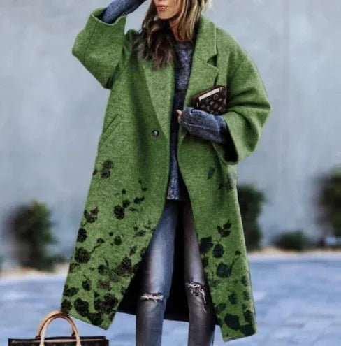 Femme portant un manteau vert à motifs floraux, jeans déchirés, gants gris, tenant un sac à main. Mode automne-hiver, style urbain chic.