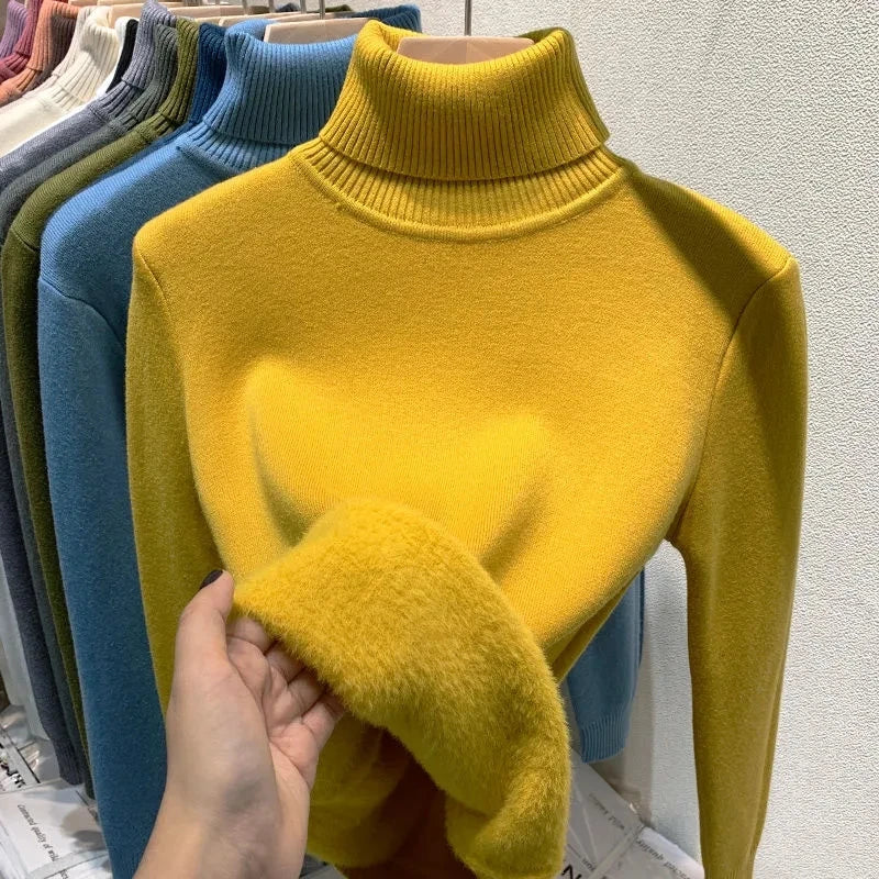 Pull col roulé jaune en laine douce, exposé sur un cintre avec d'autres couleurs. Mode automne-hiver, vêtements chauds et confortables.
