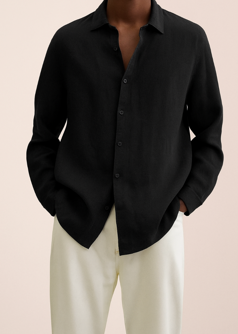 Chemise noire élégante en lin pour homme, manches longues, col classique, portée avec un pantalon beige. Mode masculine chic et décontractée.