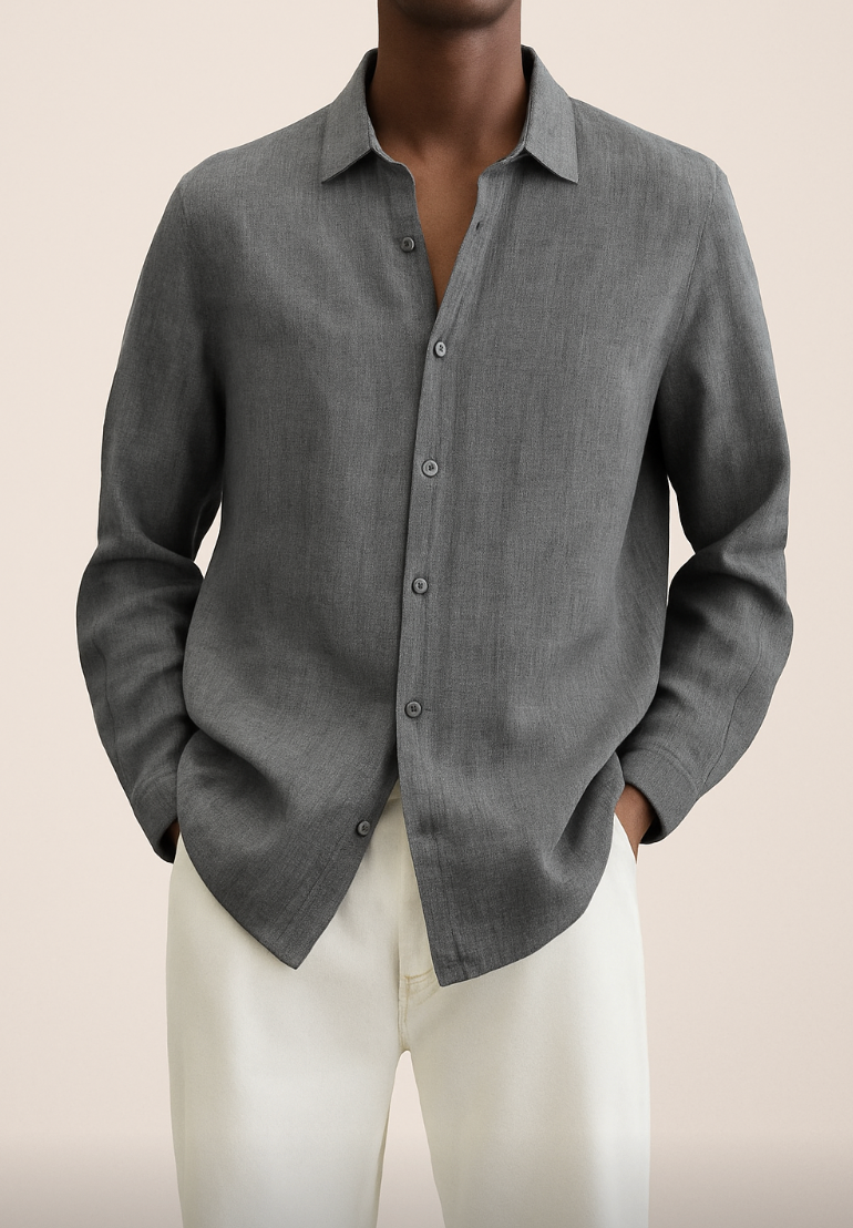 Chemise grise en lin pour homme, manches longues, col classique, portée avec un pantalon beige. Mode élégante et décontractée pour homme.