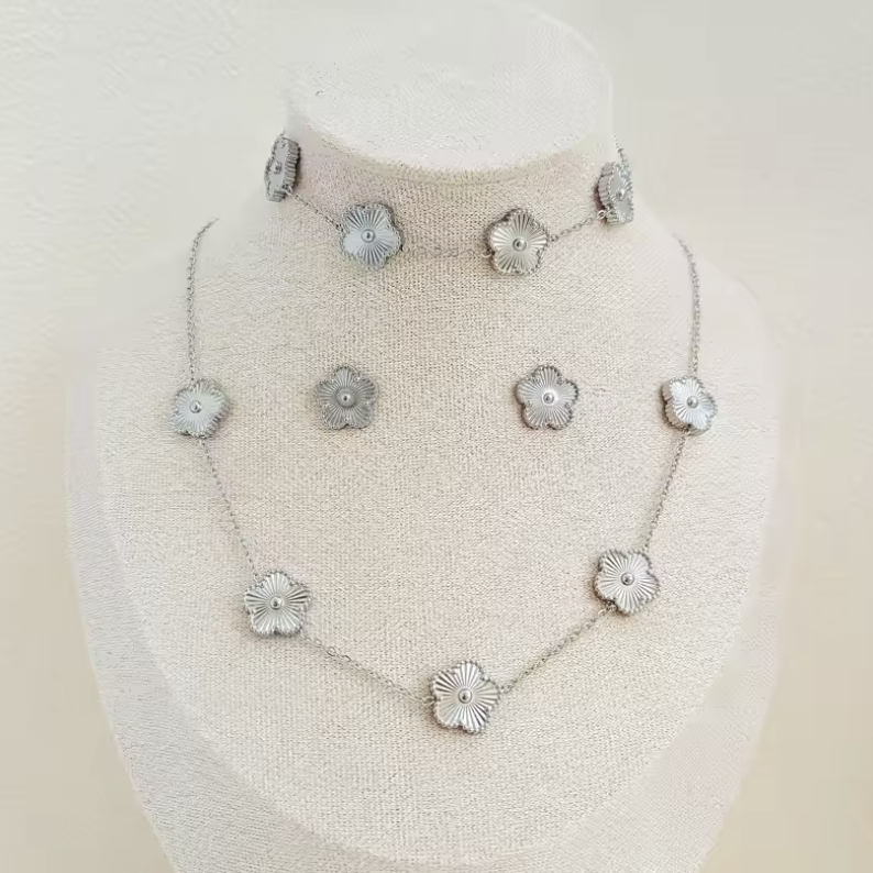 Collier et bracelet en argent avec pendentifs floraux sur un présentoir. Bijoux élégants, design floral, accessoires mode femme.