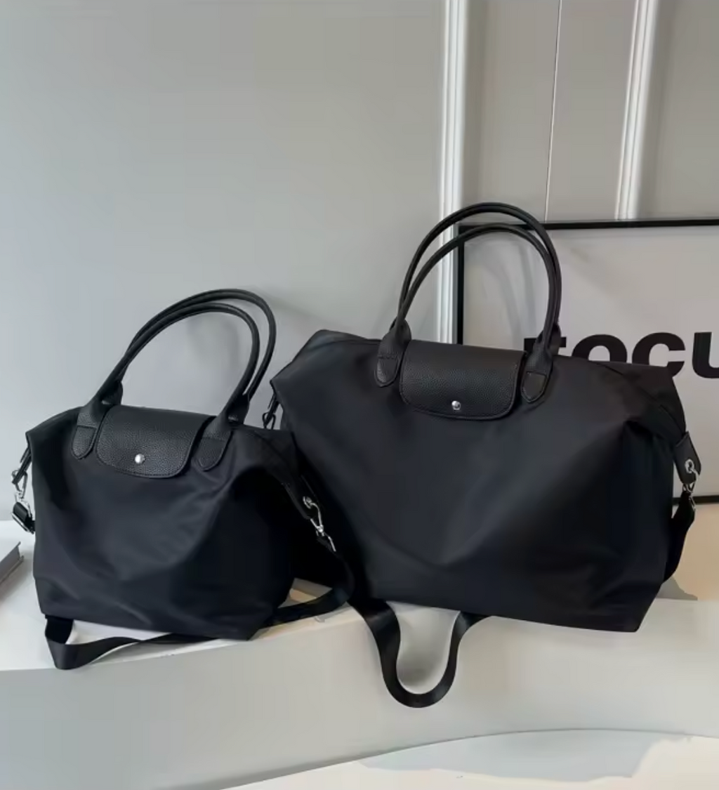Deux sacs à main noirs élégants en toile avec poignées en cuir, posés sur une surface blanche. Accessoires de mode chic et tendance.