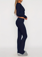 Femme en tenue de sport noire, leggings et haut à manches longues, posant de profil. Mode fitness, vêtements athlétiques, style décontracté.