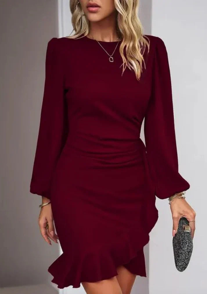 Robe bordeaux élégante avec manches longues et volants, portée par une femme tenant une pochette argentée. Mode féminine chic et tendance.