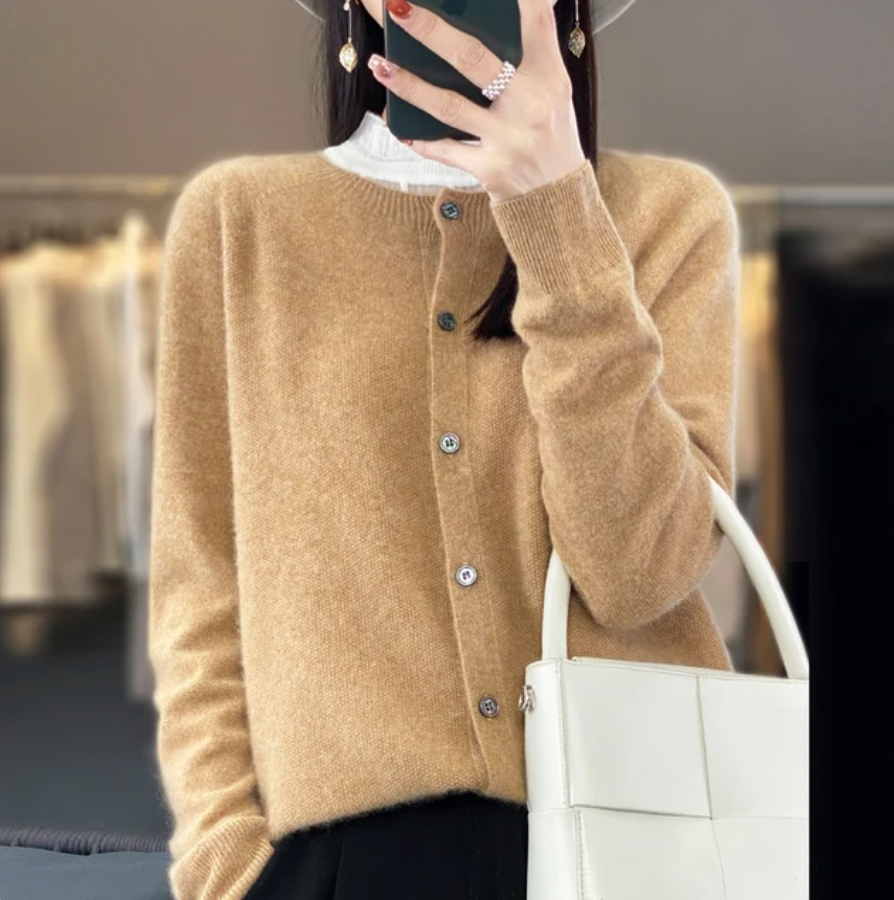 Femme portant un cardigan en laine beige, tenant un sac blanc. Mode automne, style élégant, vêtements chics, accessoires tendance.