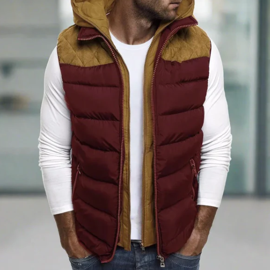 Gilet matelassé bordeaux et marron pour homme, sans manches, avec capuche, porté sur un t-shirt blanc à manches longues, style décontracté.