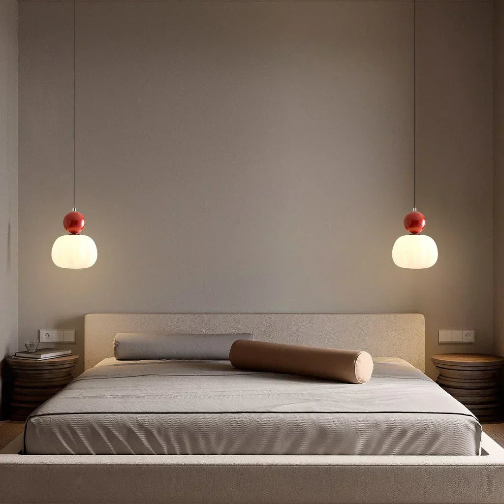 Chambre moderne avec lit double, éclairage suspendu design, murs neutres, et décoration minimaliste. Ambiance chaleureuse et épurée.