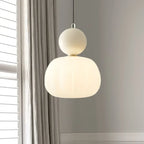 Suspension moderne en verre blanc, design minimaliste, éclairage intérieur élégant, près d'une fenêtre avec rideaux gris, ambiance contemporaine.
