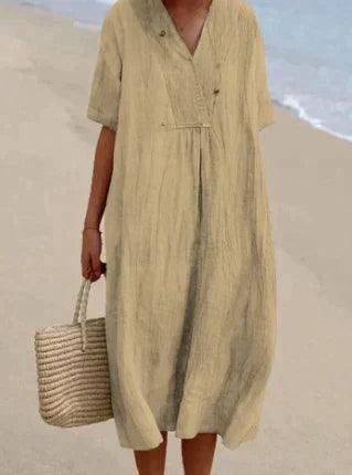 Robe en lin beige sur plage, tenue d'été élégante. Femme tenant un sac en osier, mode estivale, style décontracté bord de mer.