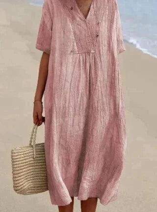 Robe d'été rose en lin sur plage, tenue décontractée, mode féminine, sac en osier, style estival, vêtements légers, bord de mer.