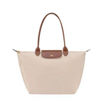 Sac à main beige élégant avec anses marron, design minimaliste, idéal pour la mode féminine. Accessoire chic et pratique pour toutes occasions.