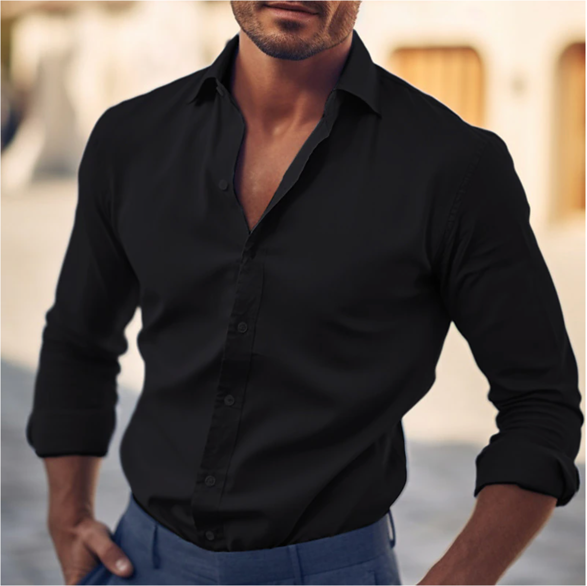 Homme portant une chemise noire élégante, manches retroussées, en extérieur urbain. Mode masculine, style chic, tenue décontractée.