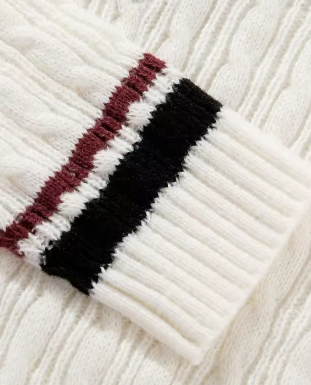 Manche de pull en maille torsadée blanche avec rayures noires et bordeaux, style élégant et chaud, mode automne-hiver, vêtement tendance.