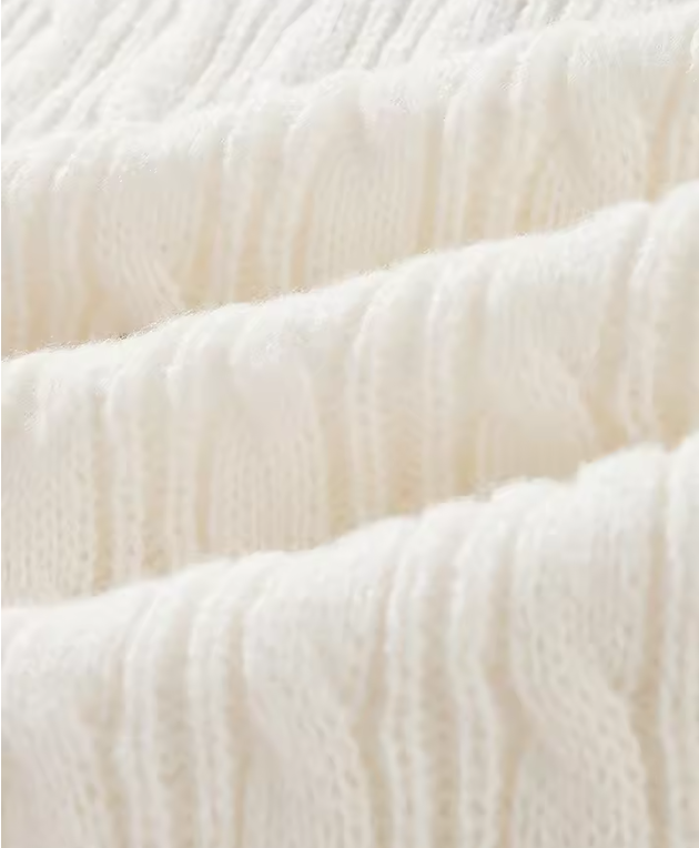 Texture de tissu en laine blanche, motif côtelé, doux et chaud, idéal pour vêtements d'hiver. Fond neutre, style élégant et confortable.