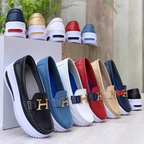 Chaussures mocassins en cuir multicolores pour hommes, avec semelles blanches et logo doré, exposées en extérieur sur une boîte blanche.