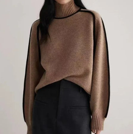 Femme portant un pull marron à col roulé avec bordures noires, associé à une jupe noire. Mode automne-hiver, style élégant et minimaliste.