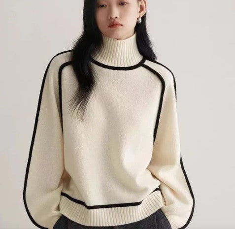 Jeune femme portant un pull blanc à col roulé avec bordures noires, style minimaliste, mode automne-hiver, élégance décontractée.