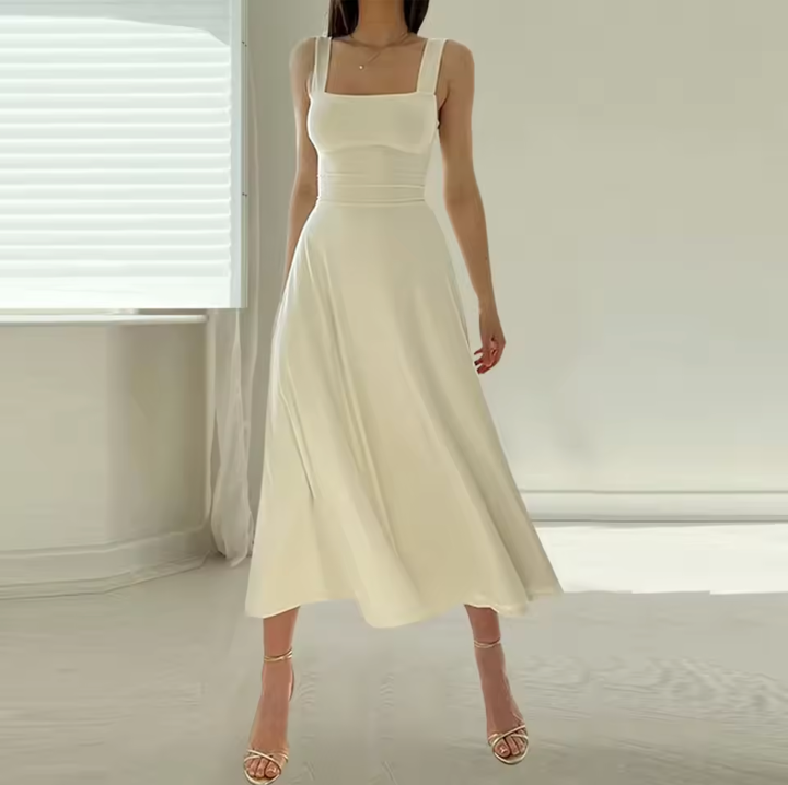 Robe blanche élégante, longueur mi-mollet, sans manches, portée par une femme. Style minimaliste, parfait pour un look chic et moderne.