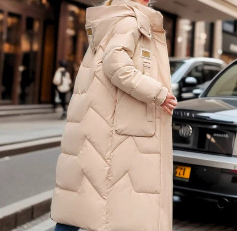 Manteau long en duvet beige pour femme, style moderne, rue urbaine, hiver, mode élégante, confort et chaleur, tendance vestimentaire.