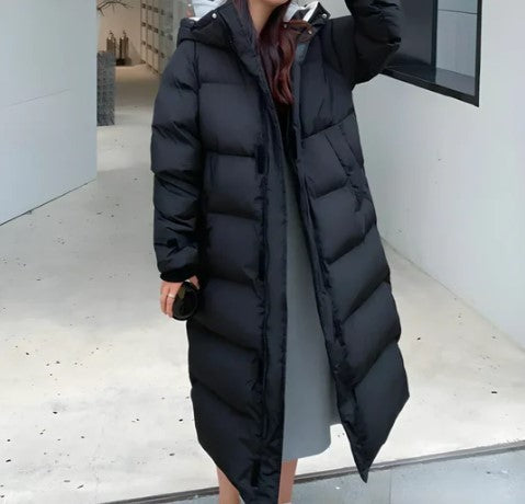 Personne portant un long manteau doudoune noir, élégant et chaud, idéal pour l'hiver. Mode féminine, vêtement d'extérieur tendance.