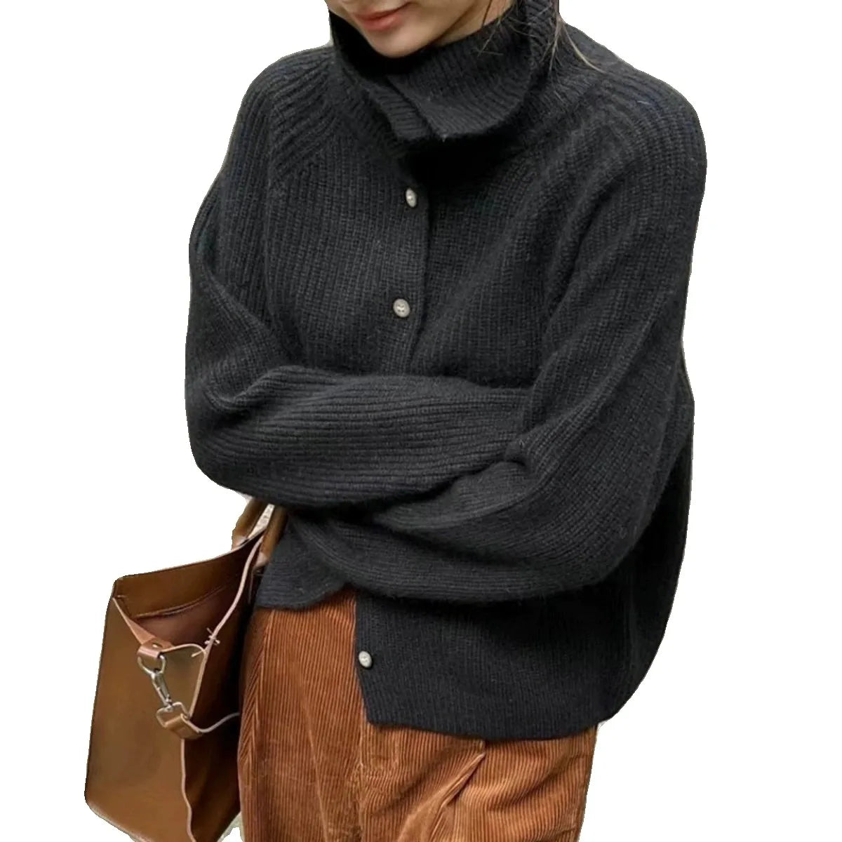 Femme portant un pull en laine noir à col montant avec boutons, associée à un pantalon en velours côtelé marron et un sac en cuir marron.