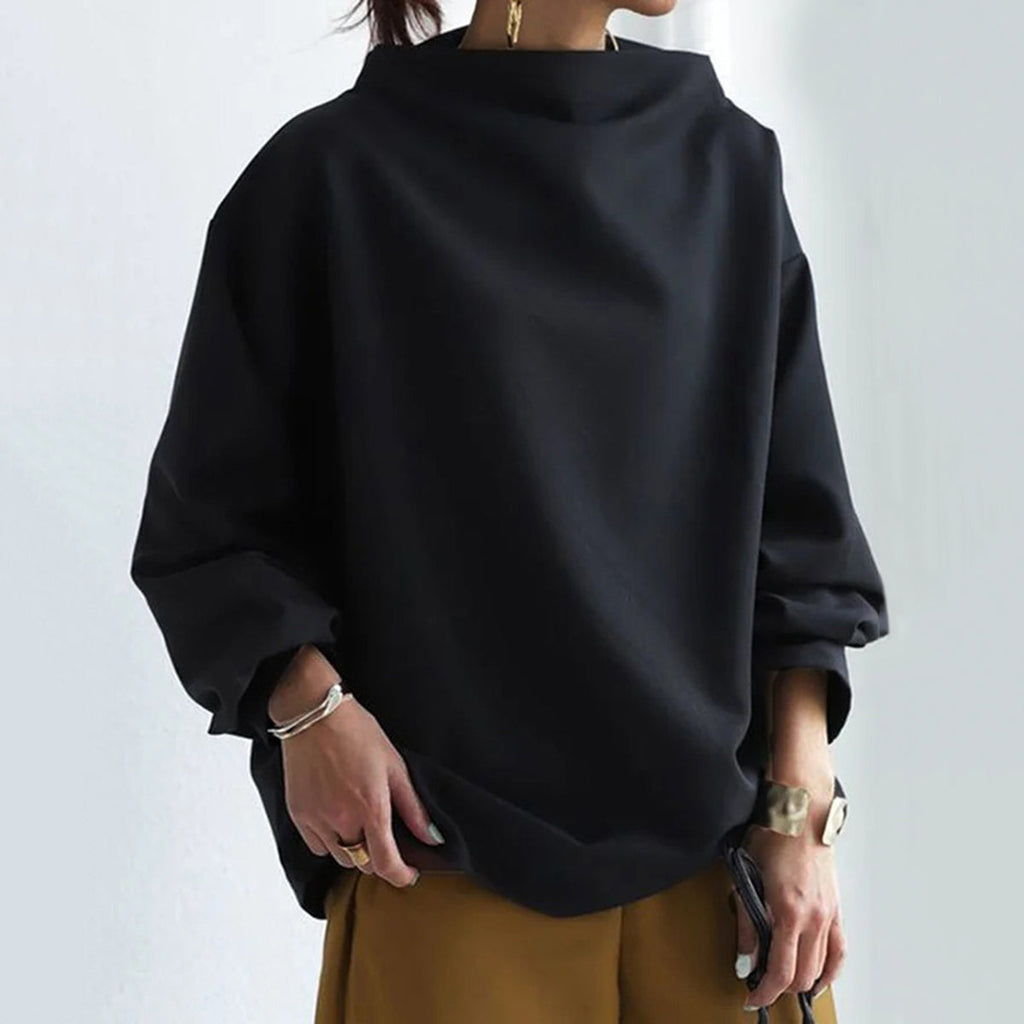 Pull noir ample à col roulé, manches longues, porté avec un pantalon marron. Style décontracté et moderne, idéal pour la mode automne-hiver.