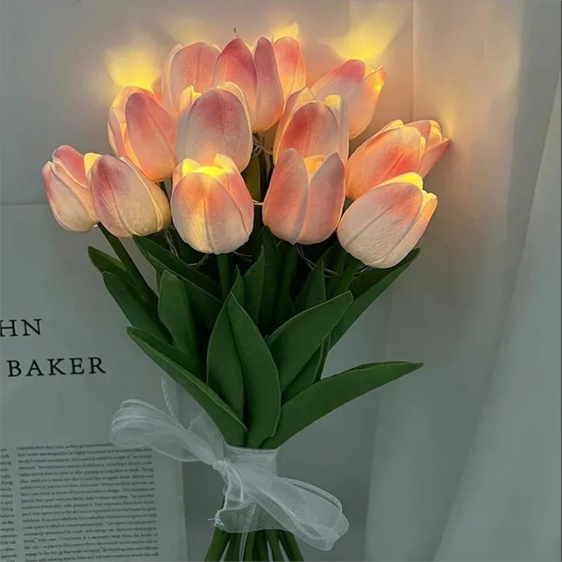 Bouquet de tulipes roses illuminées, ruban blanc, décoration intérieure élégante, ambiance chaleureuse, fleurs artificielles réalistes.