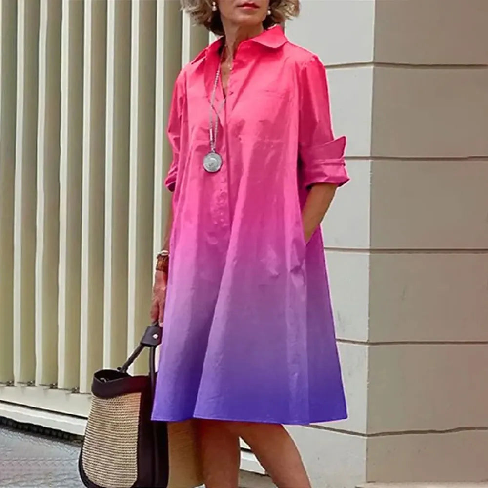 Robe dégradée rose-violet élégante, manches longues, col chemise, portée par une femme avec sac en osier, devant un mur moderne.