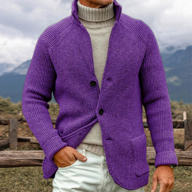 Homme portant un cardigan violet en tricot avec col montant, sur un pull beige, en plein air. Mode masculine, style automne-hiver, vêtements chauds.