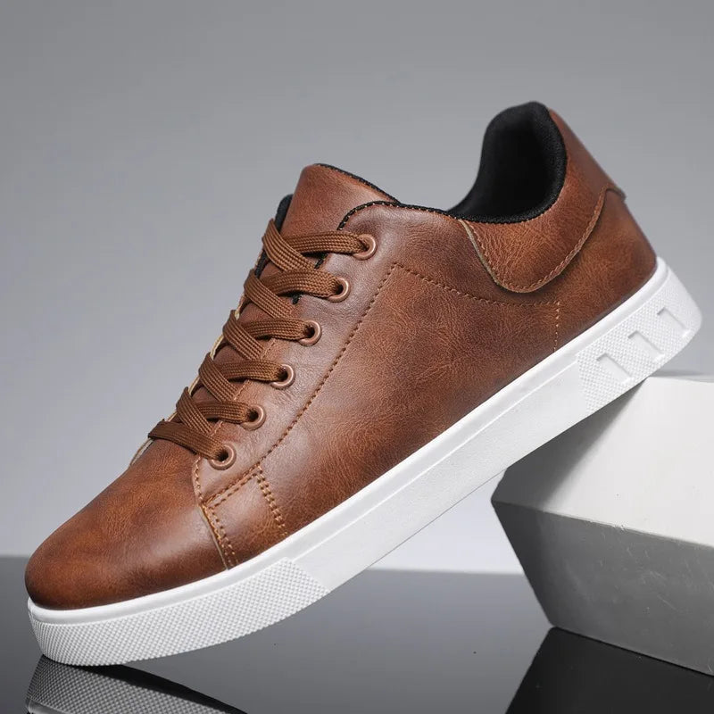 Chaussure en cuir marron pour homme, style décontracté, semelle blanche, lacets assortis, posée sur un fond gris. Sneakers tendance et élégantes.