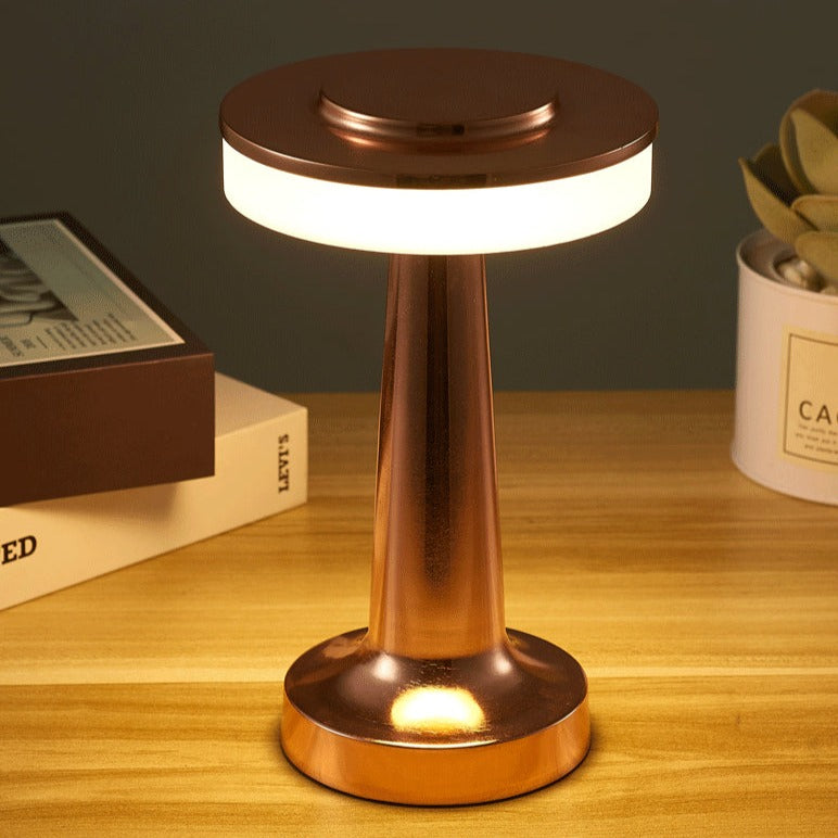 Lampe de table LED moderne en cuivre sur bureau en bois, éclairage d'ambiance élégant, design minimaliste, décoration intérieure contemporaine.