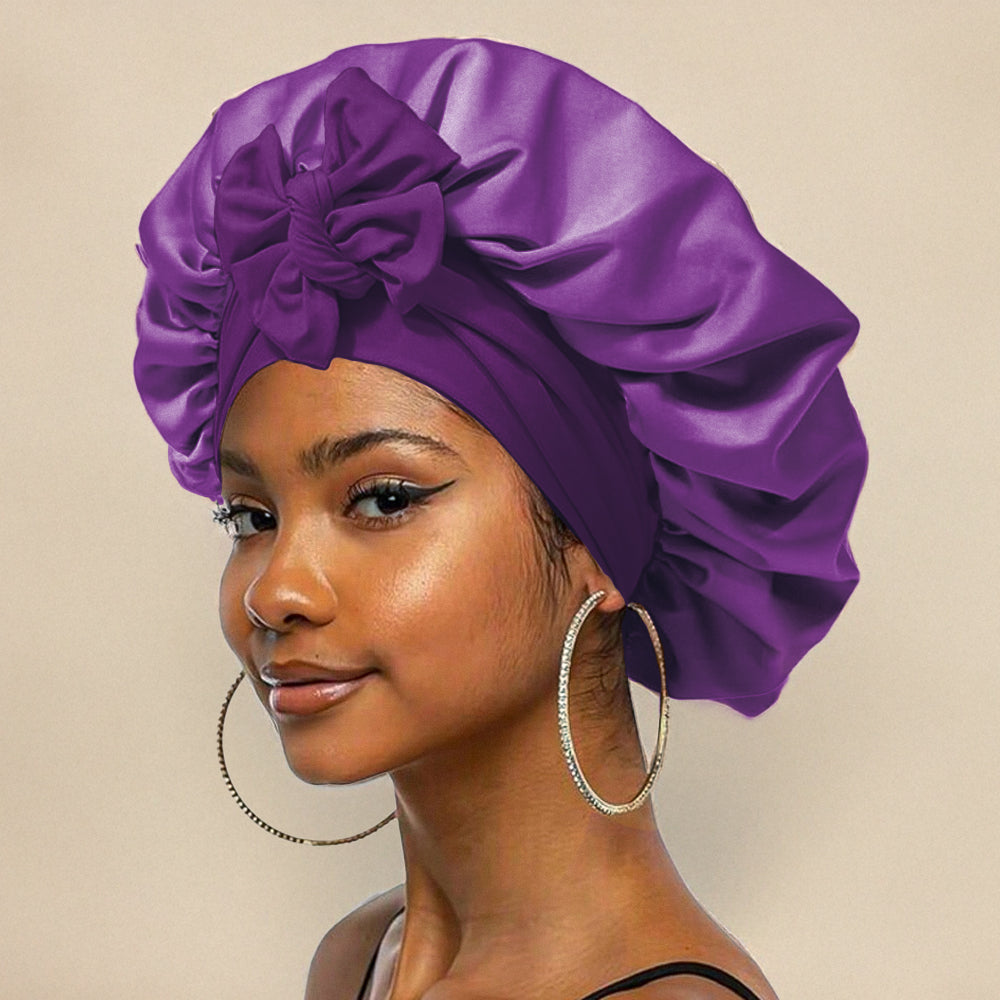 Jeune femme portant un bonnet en satin violet avec un nœud, boucles d'oreilles créoles, fond beige. Mode, accessoires cheveux, style élégant.