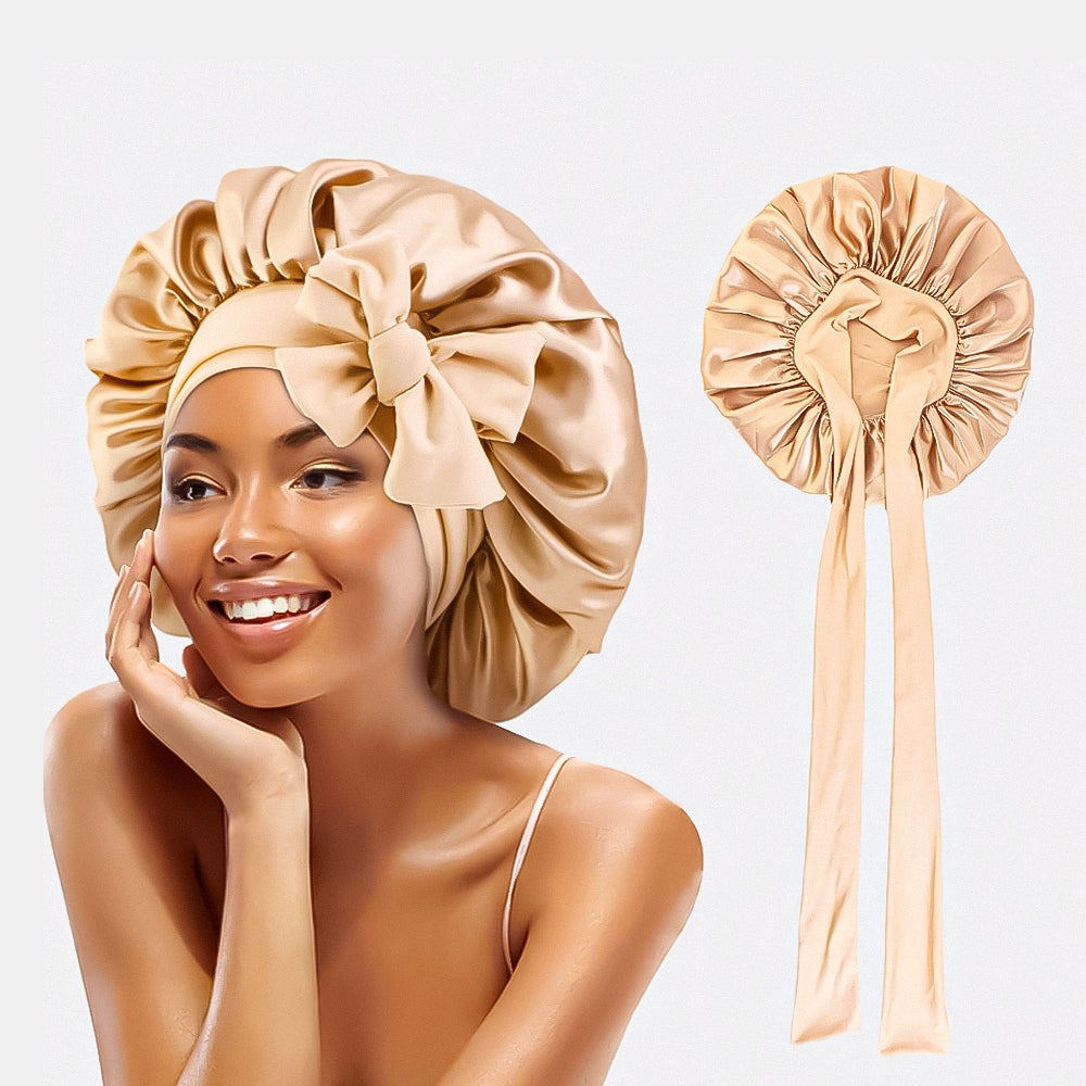 Femme souriante portant un bonnet en satin doré avec un nœud, idéal pour protéger les cheveux. Accessoire de mode élégant et pratique.