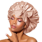 Femme portant un bonnet en satin rose avec un grand nœud, maquillage élégant, peau éclatante. Accessoire de mode, soin des cheveux, beauté féminine.
