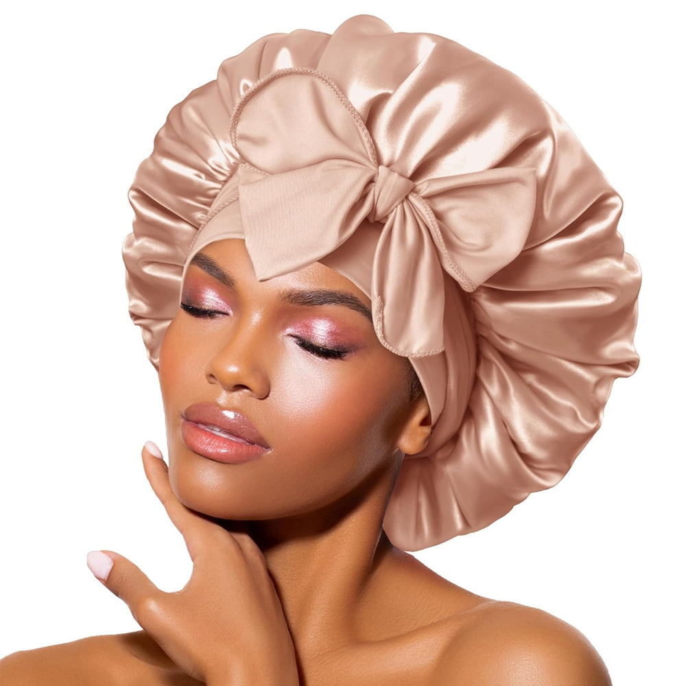 Femme portant un bonnet en satin rose avec un grand nœud, maquillage élégant, peau éclatante. Accessoire de mode, soin des cheveux, beauté féminine.