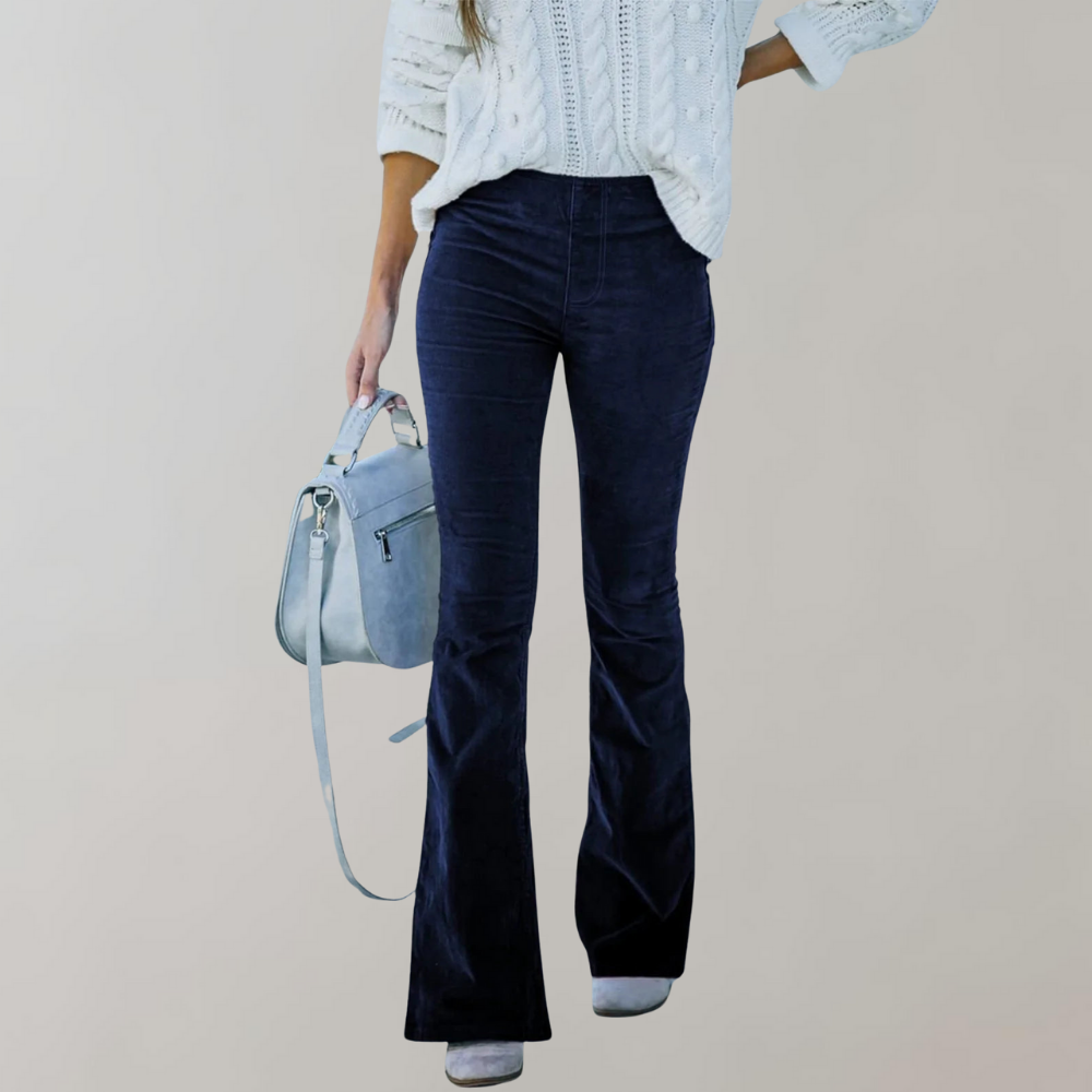 Femme portant un pull blanc en maille torsadée, pantalon bleu marine évasé, et sac à main bleu clair. Mode automne-hiver, tenue élégante et décontractée.