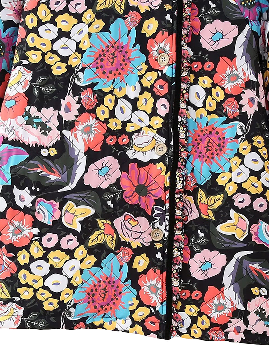 Veste à motifs floraux colorés avec boutons en bois, fond noir. Design vibrant avec fleurs roses, jaunes, bleues et blanches. Mode tendance.