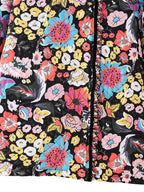 Veste à motifs floraux colorés avec boutons en bois, fond noir. Design vibrant avec fleurs roses, jaunes, bleues et blanches. Mode tendance.