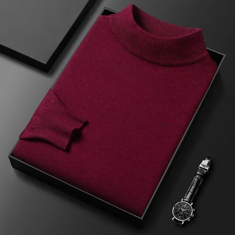Pull bordeaux en laine plié dans une boîte noire, accompagné d'une montre-bracelet élégante. Mode homme, vêtements d'hiver, style chic.
