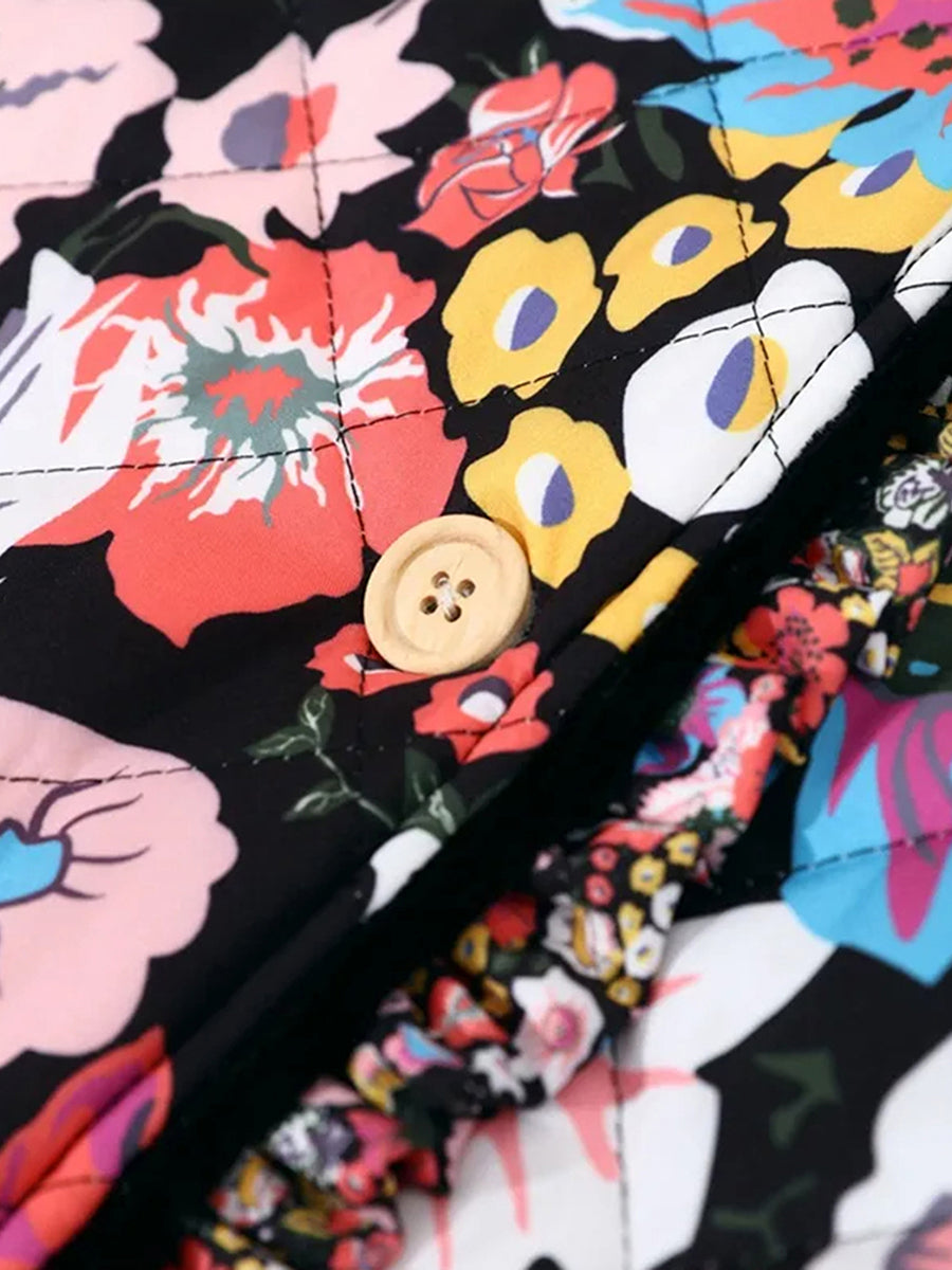 Gros plan sur un tissu matelassé à motifs floraux colorés avec bouton en bois, idéal pour la mode printemps-été. Design vibrant et tendance.