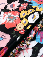 Gros plan sur un tissu matelassé à motifs floraux colorés avec bouton en bois, idéal pour la mode printemps-été. Design vibrant et tendance.