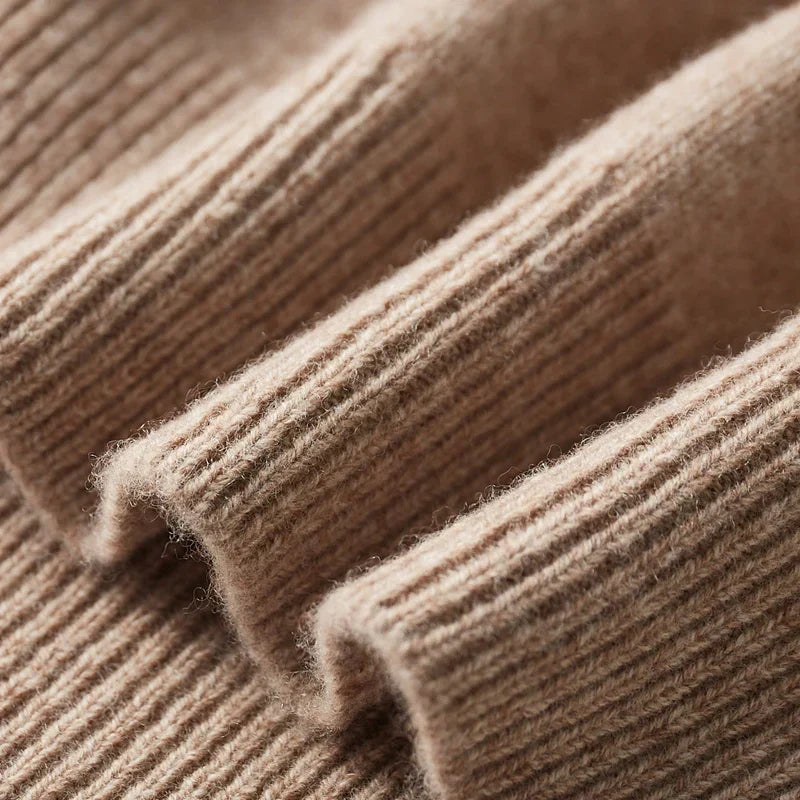 Gros plan sur un pull en cachemire beige, texture côtelée douce et luxueuse, idéal pour l'hiver. Mode élégante et confortable.